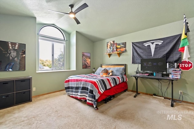 carpeted bedroom featuring vaulted ceiling, ceiling fan, and a textured ceiling