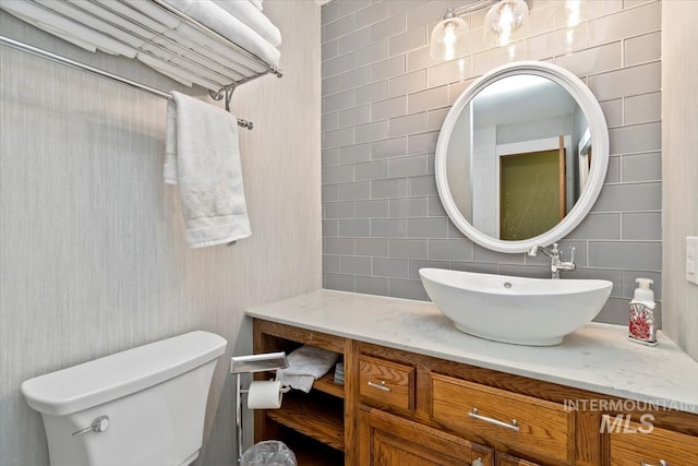 bathroom with toilet, backsplash, and vanity