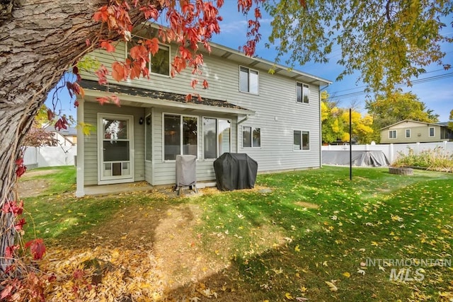 rear view of property with a yard