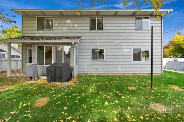 rear view of property featuring a yard