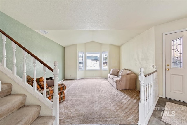 living room with light colored carpet, a textured ceiling, and lofted ceiling