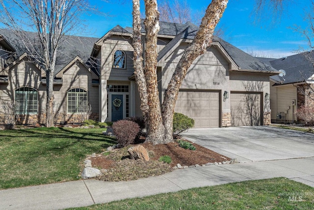1814 E Grand Canyon Dr, Meridian, ID 83646 - view of front facade with an attached garage, driveway, a front lawn, and stone siding