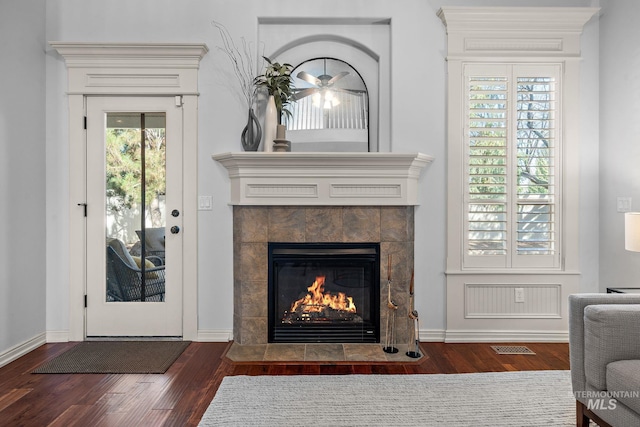 1814 E Grand Canyon Dr, Meridian, ID 83646 - room details with ceiling fan, visible vents, a tiled fireplace, wood finished floors, and baseboards