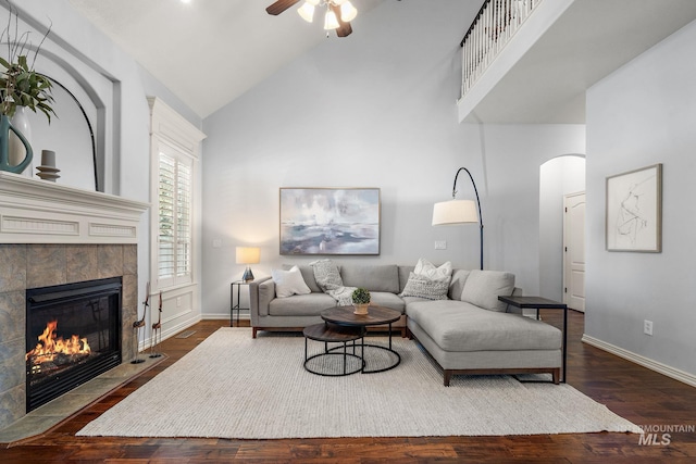 1814 E Grand Canyon Dr, Meridian, ID 83646 - living room featuring a ceiling fan, arched walkways, a tile fireplace, high vaulted ceiling, and dark wood-type flooring