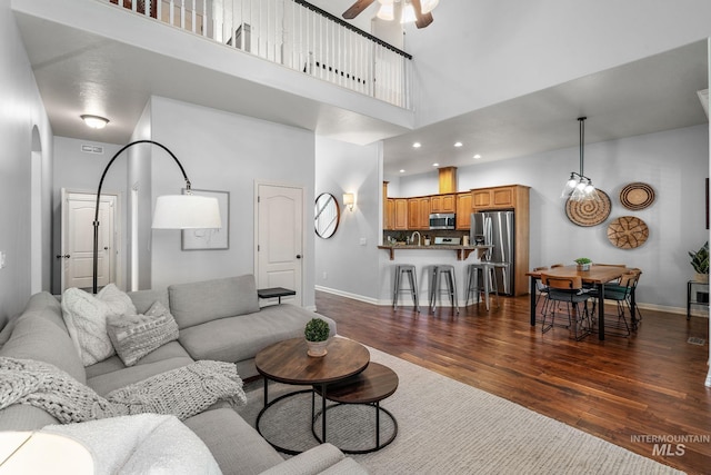 1814 E Grand Canyon Dr, Meridian, ID 83646 - living room with baseboards, dark wood finished floors, ceiling fan, and a high ceiling