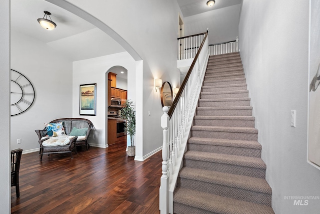 1814 E Grand Canyon Dr, Meridian, ID 83646 - staircase with baseboards, arched walkways, wood finished floors, and a towering ceiling