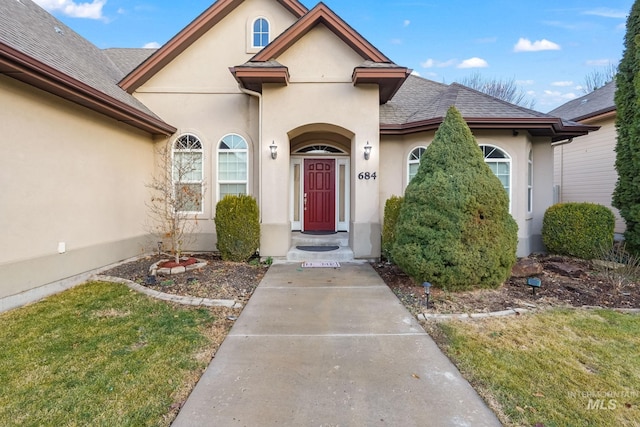 view of exterior entry with a lawn