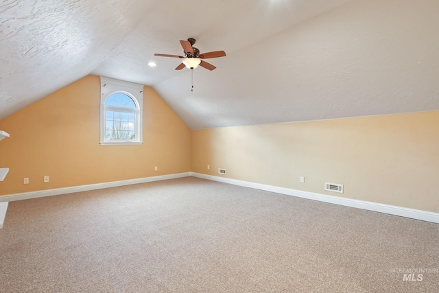 additional living space featuring ceiling fan, lofted ceiling, a textured ceiling, and carpet flooring