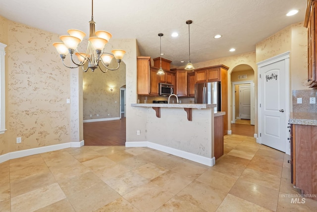 kitchen with decorative light fixtures, a breakfast bar, kitchen peninsula, and stainless steel appliances