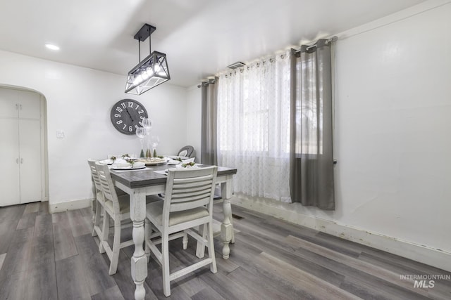 317 W C, Shoshone, ID 83352 - dining room featuring baseboards, arched walkways, and wood finished floors