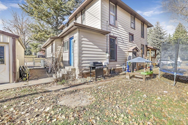 317 W C, Shoshone, ID 83352 - rear view of property featuring entry steps, fence, and a trampoline