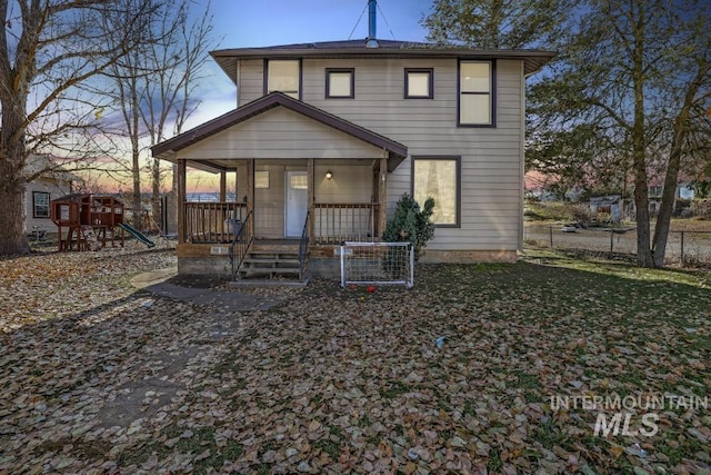 317 W C, Shoshone, ID 83352 - view of front of house featuring covered porch, fence, and a playground