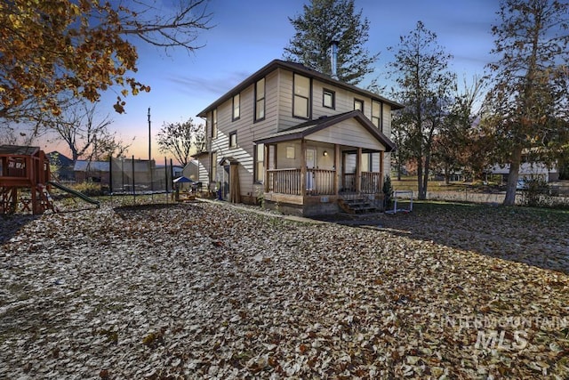 317 W C, Shoshone, ID 83352 - exterior space featuring covered porch, a playground, and a trampoline