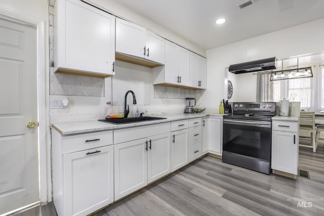 317 W C, Shoshone, ID 83352 - kitchen with a sink, stainless steel electric range, exhaust hood, and white cabinets
