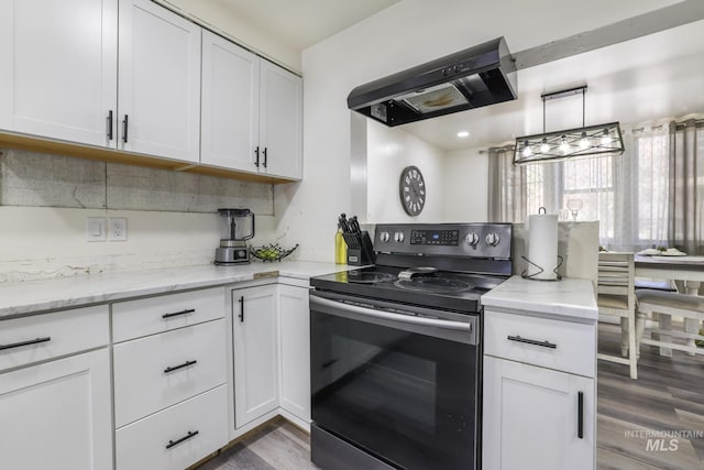 317 W C, Shoshone, ID 83352 - kitchen featuring wood finished floors, light stone countertops, extractor fan, white cabinets, and stainless steel electric range oven
