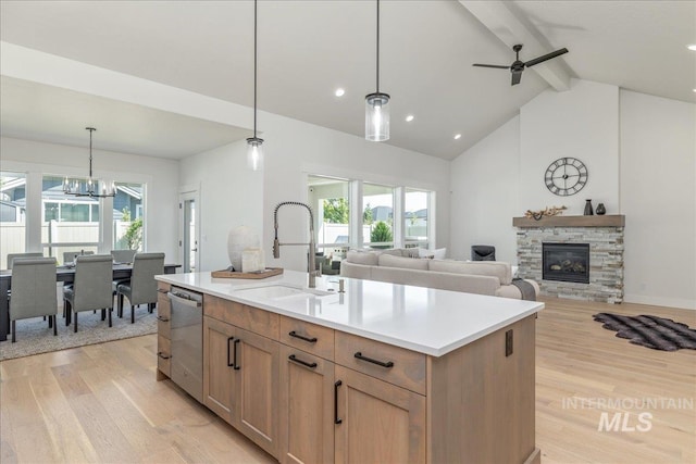 11304 W Helenium Dr, Star, ID 83669 - kitchen with dishwasher, beamed ceiling, light wood-type flooring, a fireplace, and light countertops