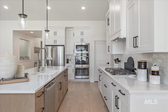 11304 W Helenium Dr, Star, ID 83669 - kitchen with stainless steel appliances, light wood-style floors, decorative backsplash, light countertops, and white cabinetry