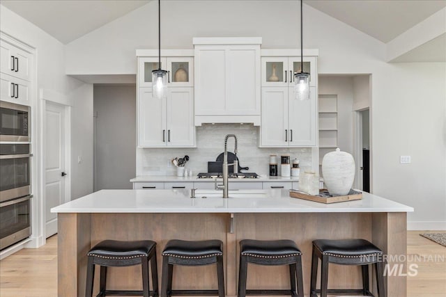 11304 W Helenium Dr, Star, ID 83669 - kitchen with vaulted ceiling, stainless steel appliances, light wood finished floors, backsplash, and light countertops