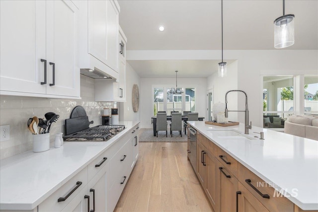 11304 W Helenium Dr, Star, ID 83669 - kitchen with stainless steel gas cooktop, light wood-type flooring, tasteful backsplash, a chandelier, and white cabinets