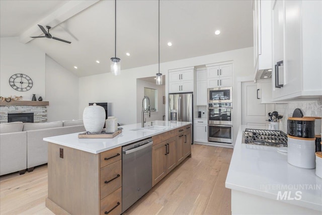 11304 W Helenium Dr, Star, ID 83669 - kitchen with appliances with stainless steel finishes, light wood-type flooring, open floor plan, a ceiling fan, and decorative backsplash