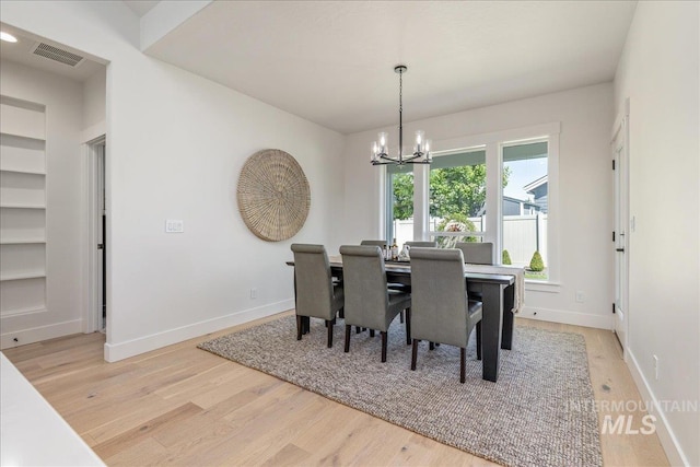 11304 W Helenium Dr, Star, ID 83669 - dining room with a chandelier, light wood finished floors, and built in shelves