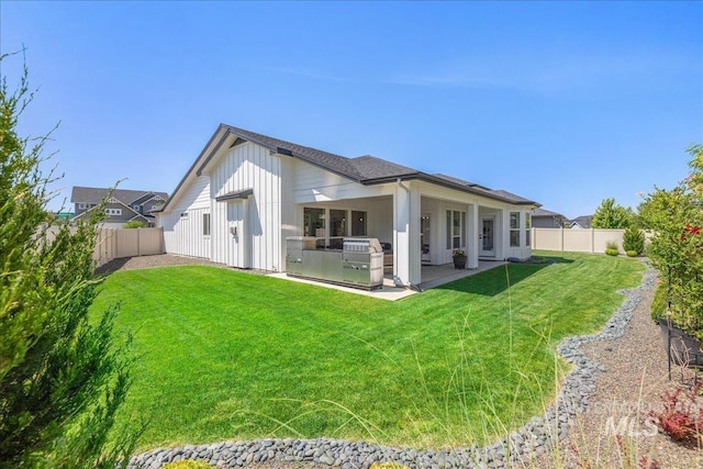 11304 W Helenium Dr, Star, ID 83669 - back of house featuring a fenced backyard, area for grilling, a patio area, and board and batten siding