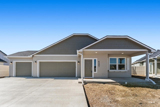 view of front facade with concrete driveway, fence, and a garage