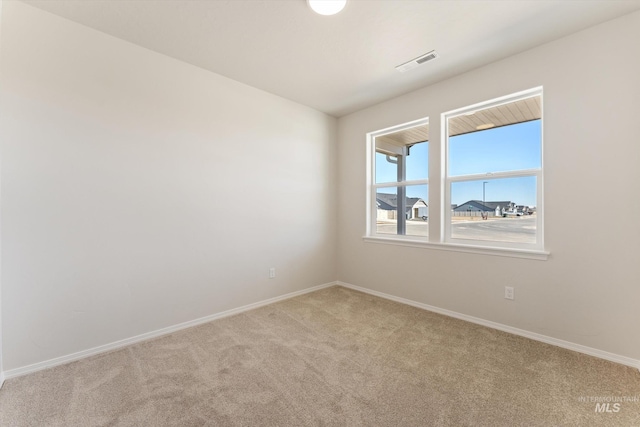 carpeted empty room featuring visible vents and baseboards