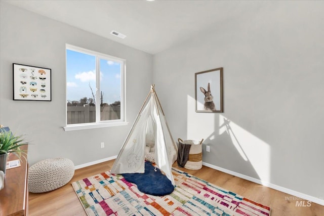 playroom with visible vents, wood finished floors, and baseboards