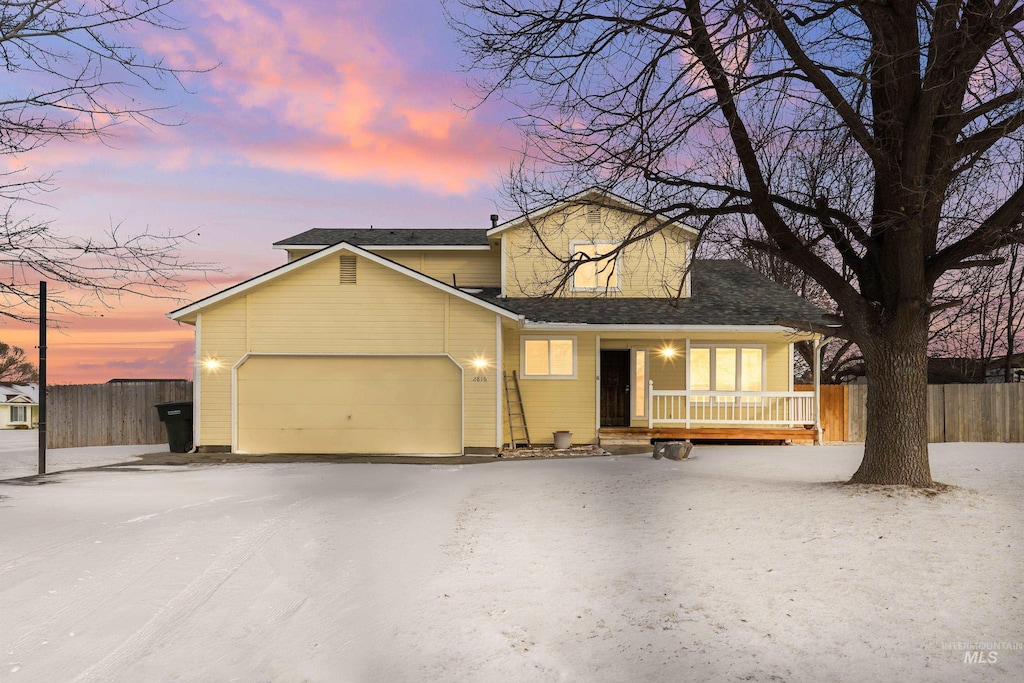 traditional home with an attached garage and fence