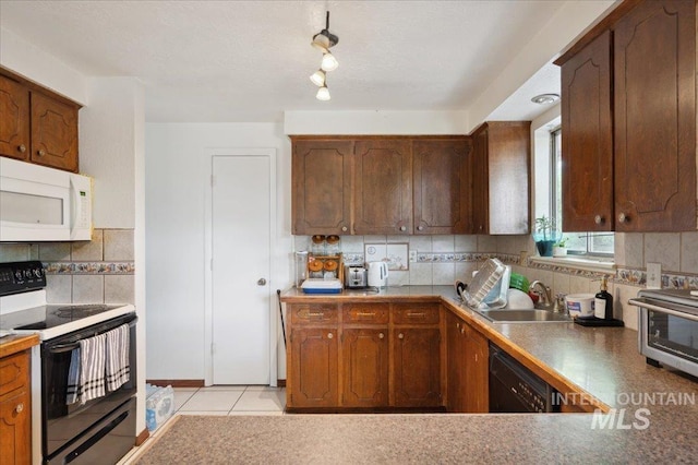 kitchen featuring range with electric stovetop, white microwave, a sink, dishwasher, and backsplash