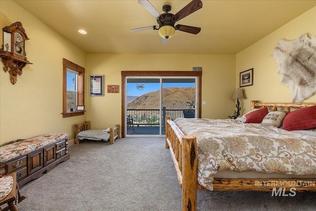 bedroom with light carpet, a mountain view, ceiling fan, access to exterior, and multiple windows