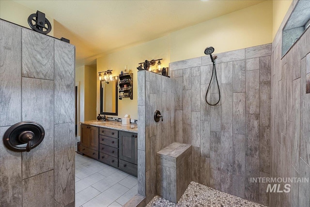 bathroom featuring vanity, tile patterned flooring, and a tile shower