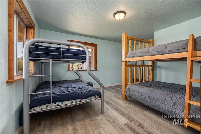 bedroom with hardwood / wood-style flooring and a textured ceiling