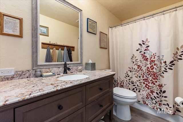 bathroom with vanity, toilet, hardwood / wood-style floors, and a textured ceiling