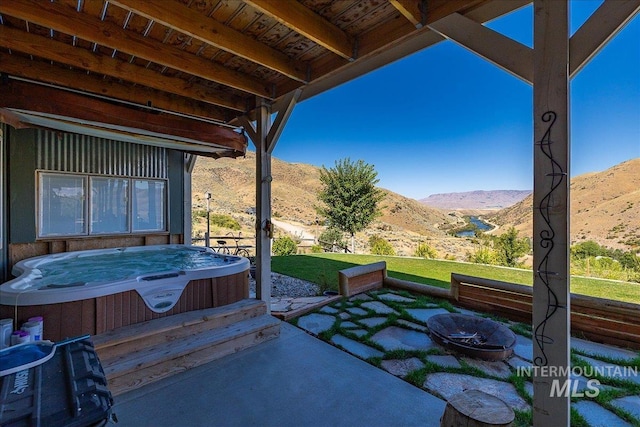 view of patio featuring a mountain view and a hot tub