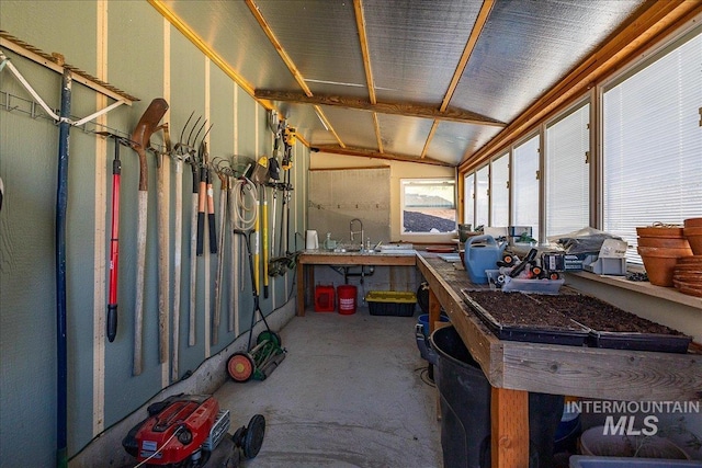 misc room featuring lofted ceiling, a workshop area, and concrete floors