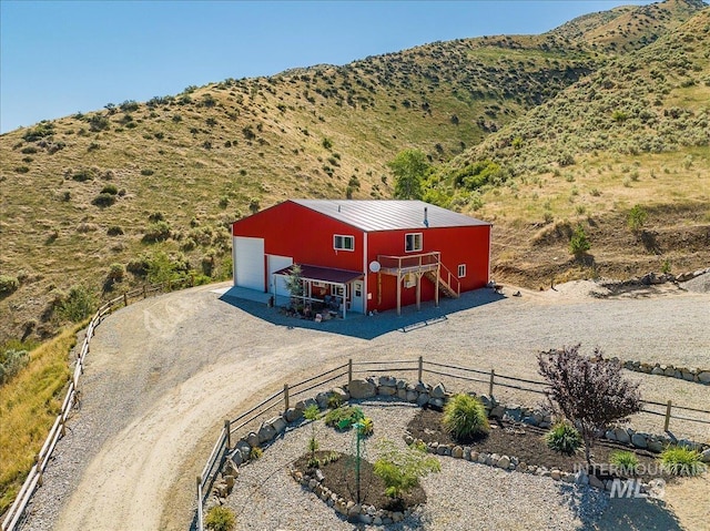 exterior space with a garage, a mountain view, and an outbuilding