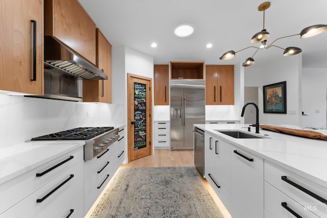 kitchen with stainless steel appliances, hanging light fixtures, sink, and white cabinets