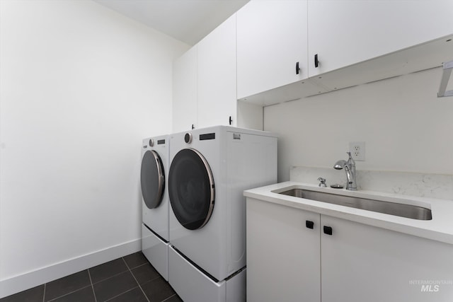 washroom with cabinets, separate washer and dryer, sink, and dark tile patterned flooring