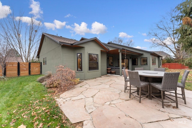 back of property with a patio area and a lawn