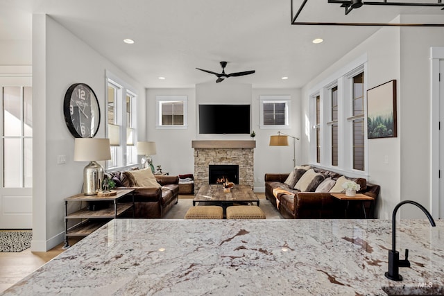 11645 N 24th Ave, Boise, ID 83714 - living area featuring a ceiling fan, wood finished floors, a stone fireplace, baseboards, and recessed lighting