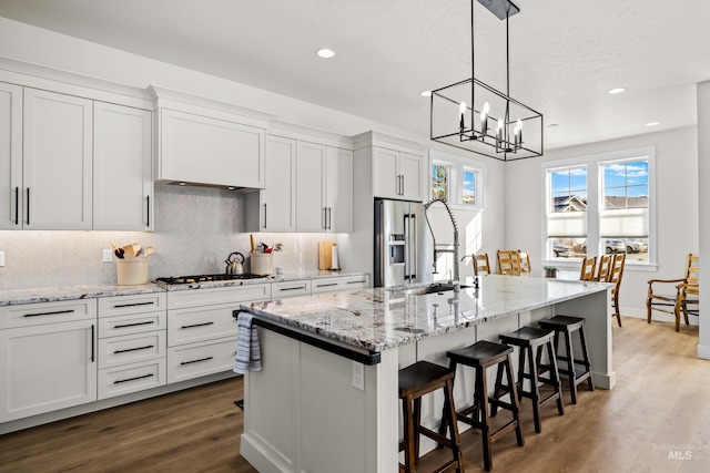 11645 N 24th Ave, Boise, ID 83714 - kitchen featuring a kitchen island with sink, high end fridge, tasteful backsplash, and dark wood-style floors