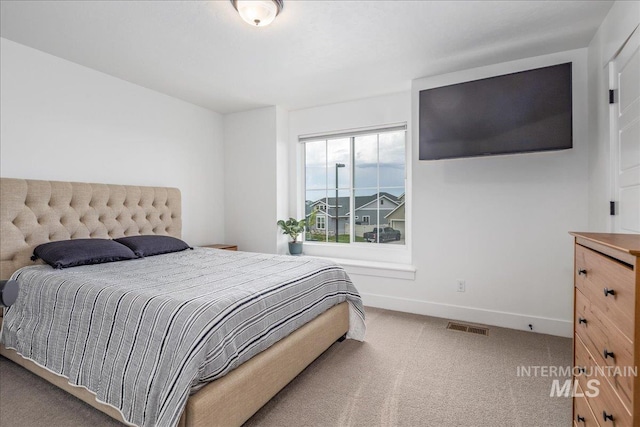 carpeted bedroom with visible vents and baseboards