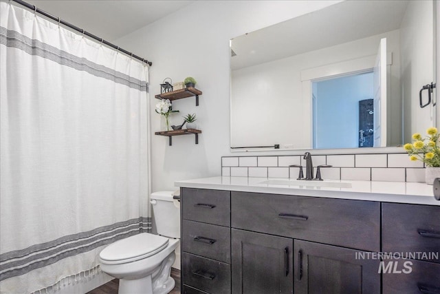 full bath with tasteful backsplash, toilet, and vanity