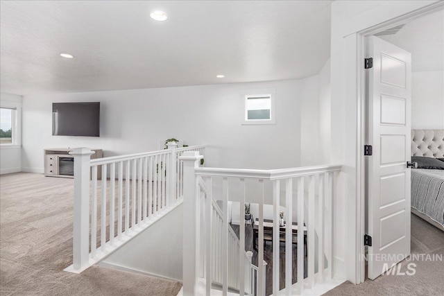 corridor featuring an upstairs landing, carpet flooring, and recessed lighting