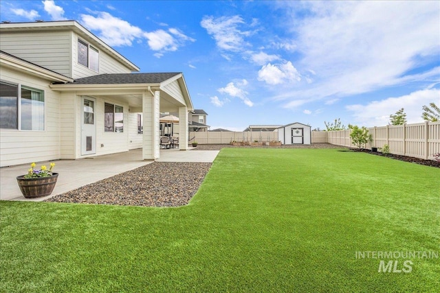 view of yard featuring a patio, an outbuilding, a fenced backyard, and a shed