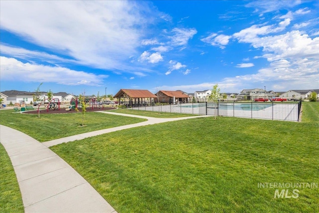 view of yard with fence, playground community, and a residential view