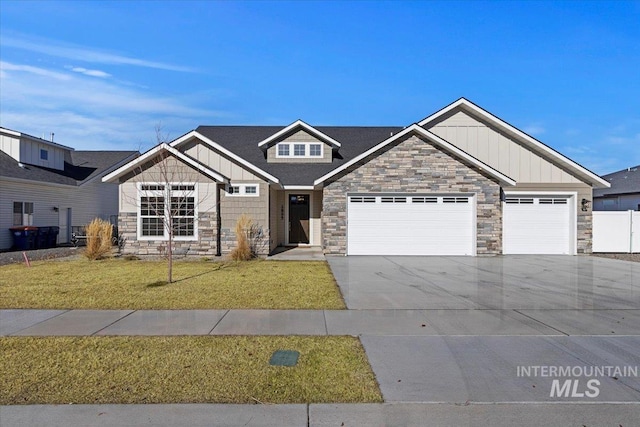 2895 Evening Sun Dr, Twin Falls, ID 83301 - view of front of house with board and batten siding, stone siding, a front yard, concrete driveway, and an attached garage