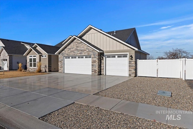 2895 Evening Sun Dr, Twin Falls, ID 83301 - craftsman house featuring stone siding, an attached garage, driveway, board and batten siding, and fence